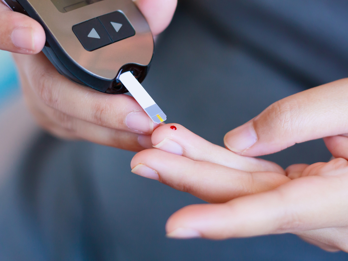 a person pricking their finger to take a blood sample for a blood sugar test